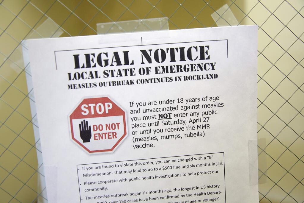 A sign explaining a local state of emergency because of a measles outbreak in 2019 in New York. (SETH WENIG / Associated Press, 2019)