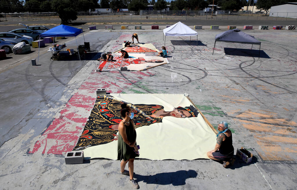 Joy Ayodele, left, views a mural of herself completed by SCAPE (Sonoma County Artists Propelling Equity) Tuesday, Aug. 4, 2020, in Roseland. Remi Newman, co-founder of SCAPE, is on the right. (Kent Porter / The Press Democrat) 2020