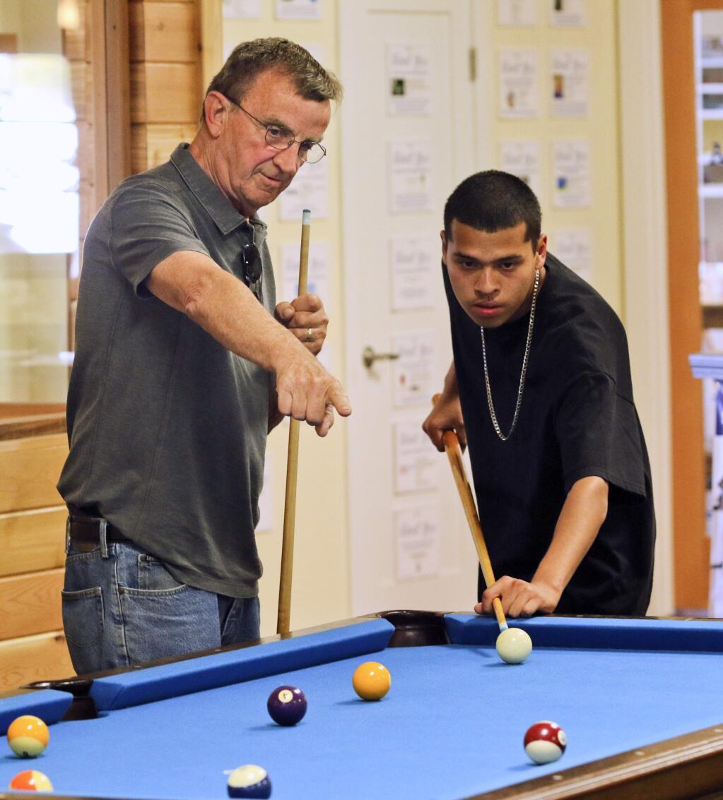 Mentor Me volunteer Kent Smith works with one of his mentees Eddie Ramos as they work together to plan out Eddie's next pool shot at the Mentor Me Center in Petaluma on Monday, April 28, 2015. (SCOTT MANCHESTER/ARGUS-COURIER STAFF)