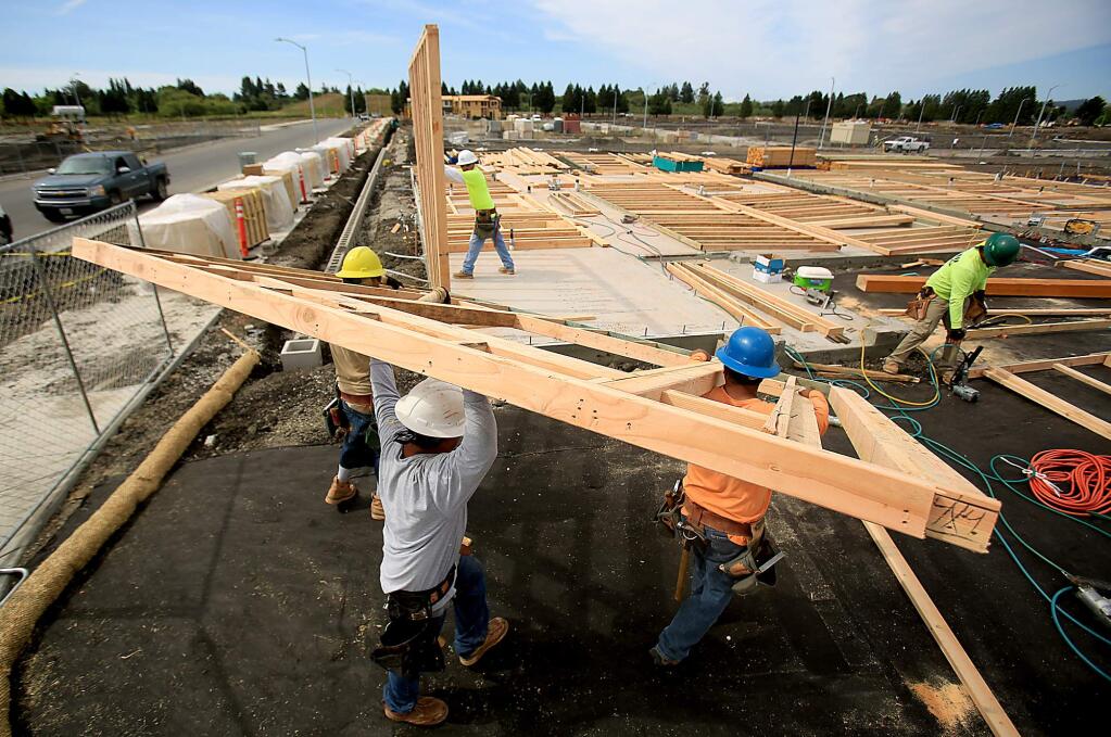Workers with Richmond American put up framing of a new home in a large housing project near Sonoma State University in Rohnert Park on Friday, June 10, 2016. (KENT PORTER/ PD)
