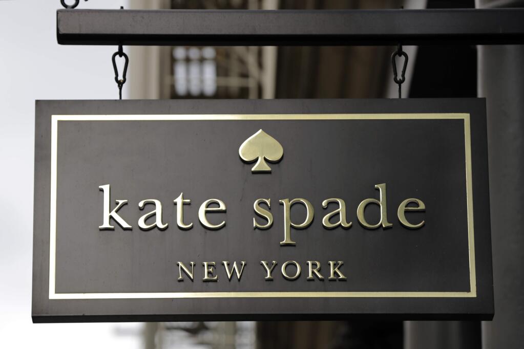 The sign for the Kate Spade store in New York's Soho neighborhood hangs above the entrance, Tuesday, June 5, 2018. Spade was found hanged in her apartment Tuesday in an apparent suicide, law enforcement officials said. (AP Photo/Richard Drew)