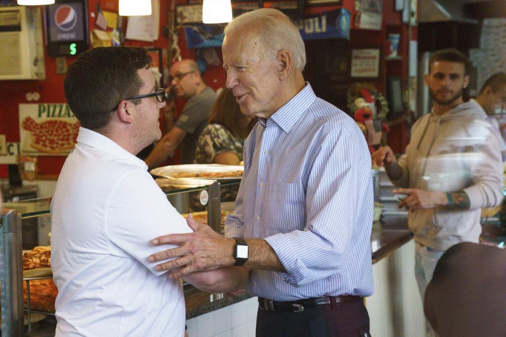 Democratic presidential candidate and former Vice President Joe Biden greets people at Gianni's Pizza, in Wilmington Del., Thursday, April 25, 2019. Jessica Griffin/The Philadelphia Inquirer via AP)