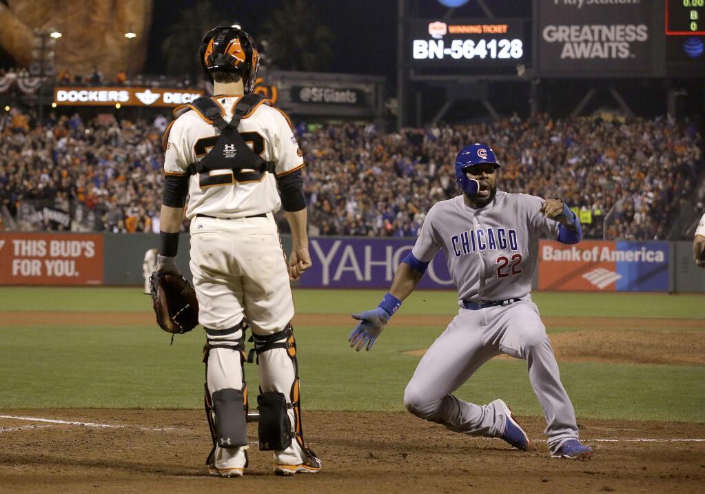 Chicago Cubs' Jason Heyward (22) celebrates after scoring next to San Francisco Giants catcher Buster Posey during the ninth inning of Game 4 of baseball's National League Division Series in San Francisco, Tuesday, Oct. 11, 2016. The Cubs won 6-5. (AP Photo/Marcio Jose Sanchez)