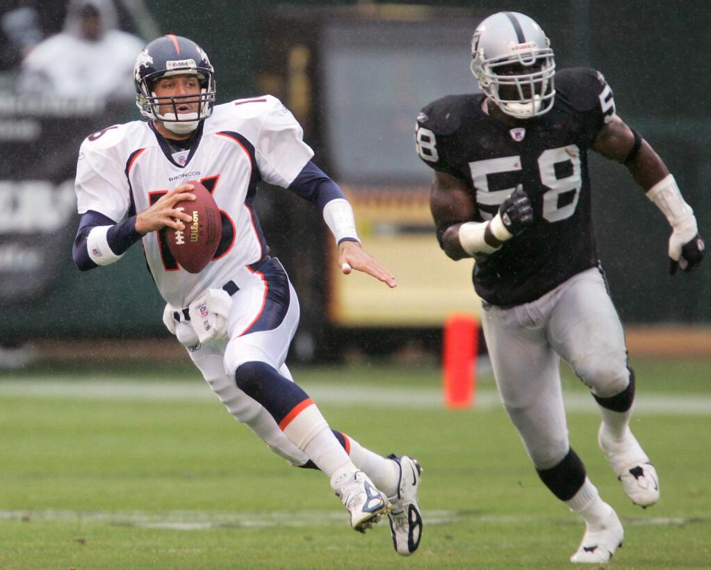 Denver Broncos quarterback Jake Plummer evades Oakland Raiders linebacker Napoleon Harris during a 2004 NFL game in Oakland. (CHRISTOPHER CHUNG/ PD FILE)