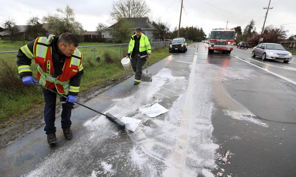 Rincon Valley firefighters Shawn Johnson, left and Rob Bisordi clean-up after a three car vehicle accident, Thursday March 15, 2018 on Stony Point Road south of Santa Rosa. (Kent Porter / The Press Democrat) 2018