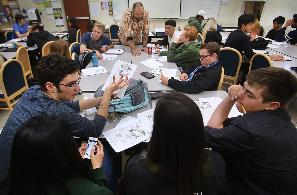 From left, Jacob Mitchell, Emi Nomura, Kail Gibson and Zach Schieberl discuss their senior AP economics classwork, Monday April 17, 2017 at Technology High School in Rohnert Park. In the background is instructor Matt Zwinge. (Kent Porter / The Press Democrat) 2017
