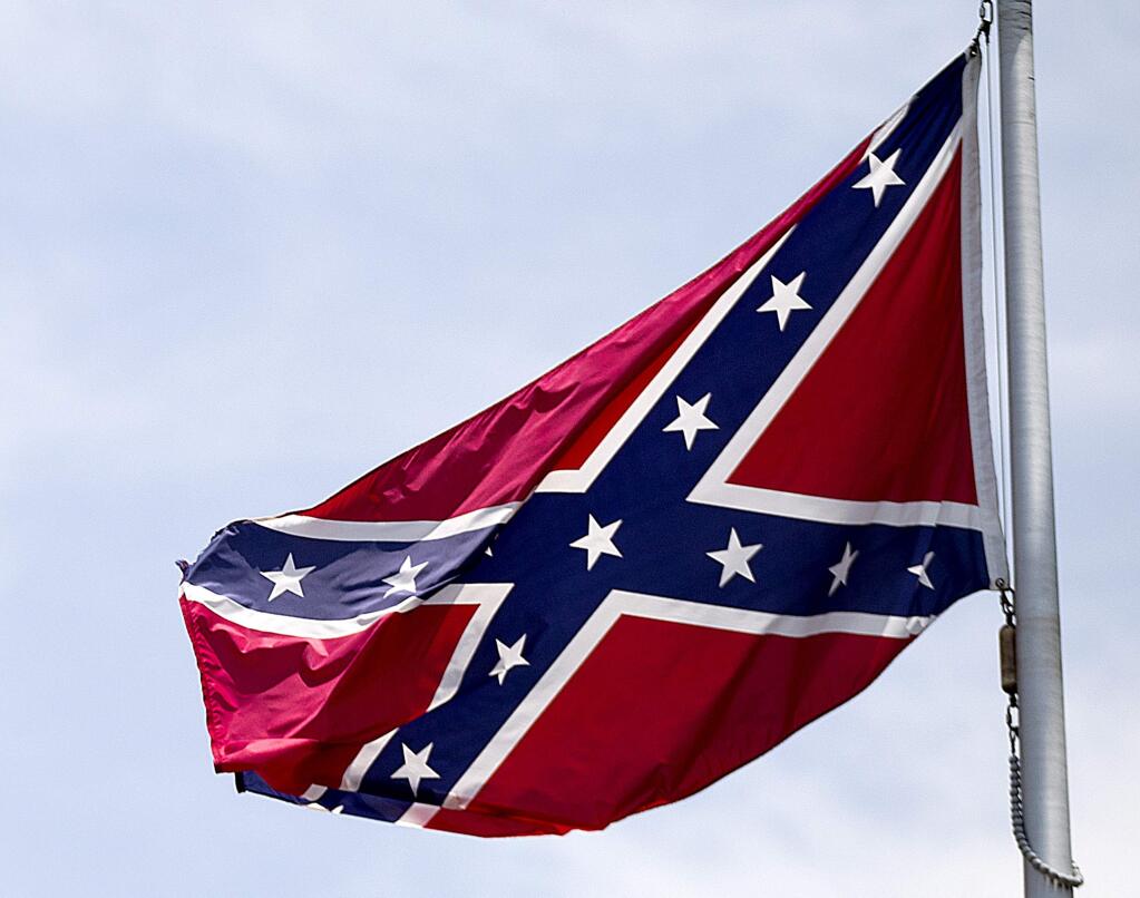 In this June 30, 2015 photo, a Confederate flag flies at the base of Stone Mountain in Stone Mountain, Ga. The House in Congress has voted to ban the display of Confederate flags at historic federal cemeteries in the deep South. The low-profile move came late Tuesday after a brief debate on a measure funding the National Park Service, which maintains 14 national cemeteries, most of which contain graves of Civil War soldiers. (AP Photo/David Goldman)