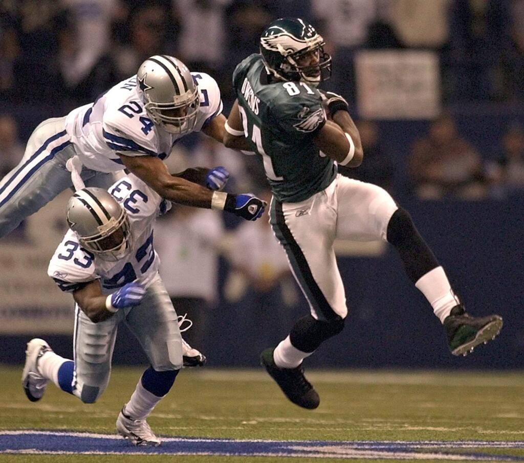 In this Nov. 15, 2004, file photo, Philadelphia Eagles wide receiver Terrell Owens (81) pulls in a 50-yard touchdown pass in front of Dallas Cowboys defenders Nathan Jones (33) and Tony Dixon (24). (AP Photo/LM Otero, File)