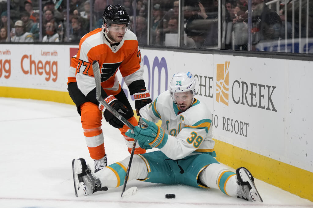 San Jose Sharks center Logan Couture (39) looks toward the puck in front of Philadelphia Flyers defenseman Tony DeAngelo (77) during the second period of an NHL hockey game in San Jose, Calif., Thursday, Dec. 29, 2022. (AP Photo/Jeff Chiu)
