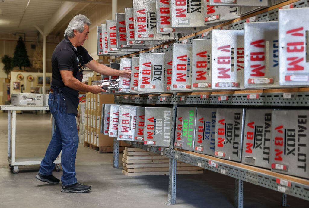 Storekeeper Juan Diaz prepares vote-by-mail ballot boxes for vote centers, with miscellaneous supplies, at the Sonoma County Registrar of Voters off-site warehouse in Santa Rosa on Monday, Oct. 3, 2022. (Christopher Chung/The Press Democrat)