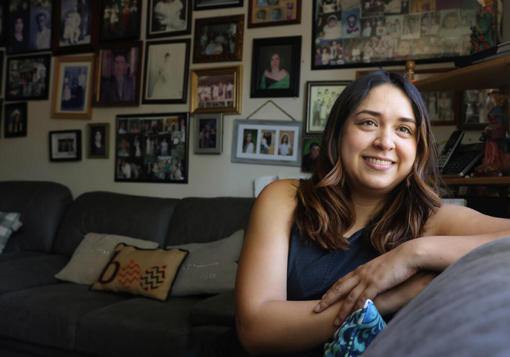 Press Democrat reporter Nashelly Chavez recalls spending time at her grandmother's apartment, where the walls are covered with photos of family members, while growing up in Petaluma.  (Christopher Chung/ The Press Democrat)