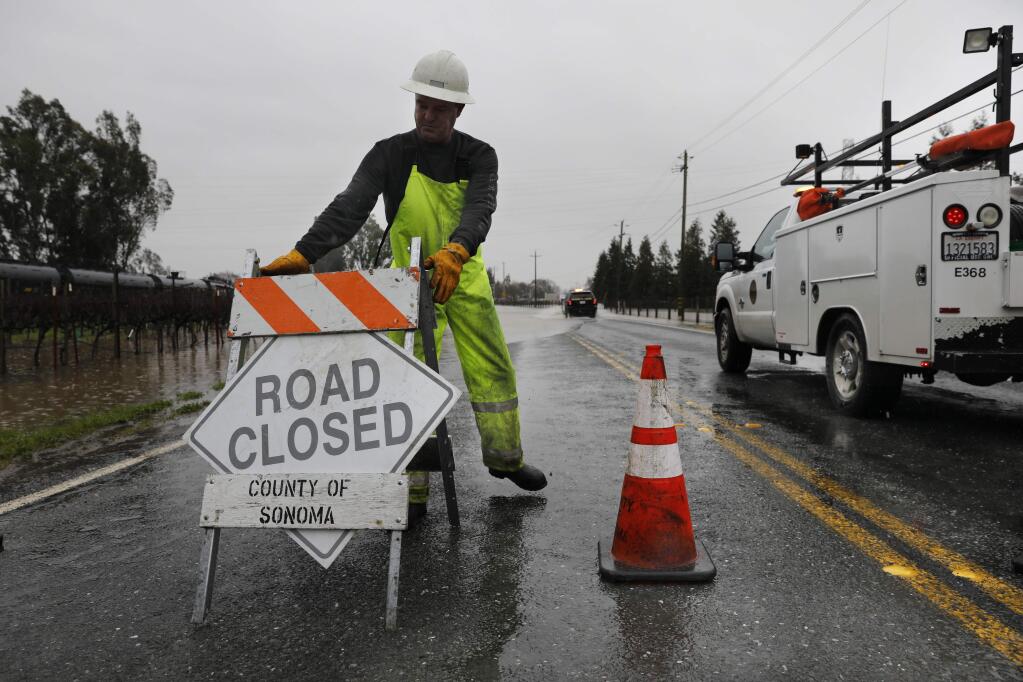 Sonoma County Roads employee Todd Fourshay closes 8th St. E as flood water covers the road in the Schellville area south of Sonoma, California on Tuesday, February 26, 2019 . (BETH SCHLANKER/The Press Democrat)