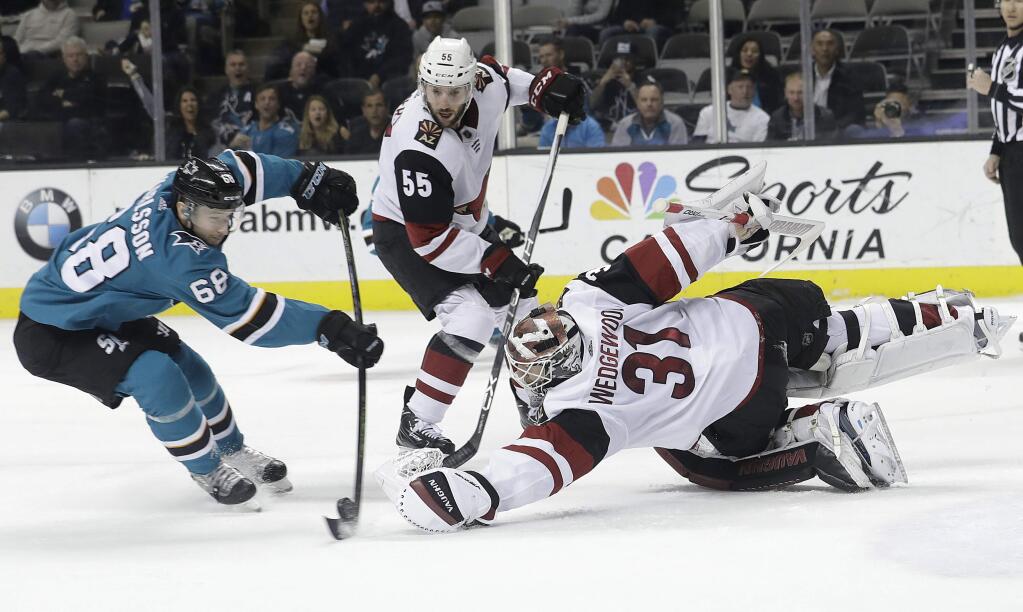 Arizona Coyotes goaltender Scott Wedgewood (31) reaches for the puck in front of San Jose Sharks right wing Melker Karlsson (68), from Sweden, during the second period Tuesday, Feb. 13, 2018. (AP Photo/Jeff Chiu)