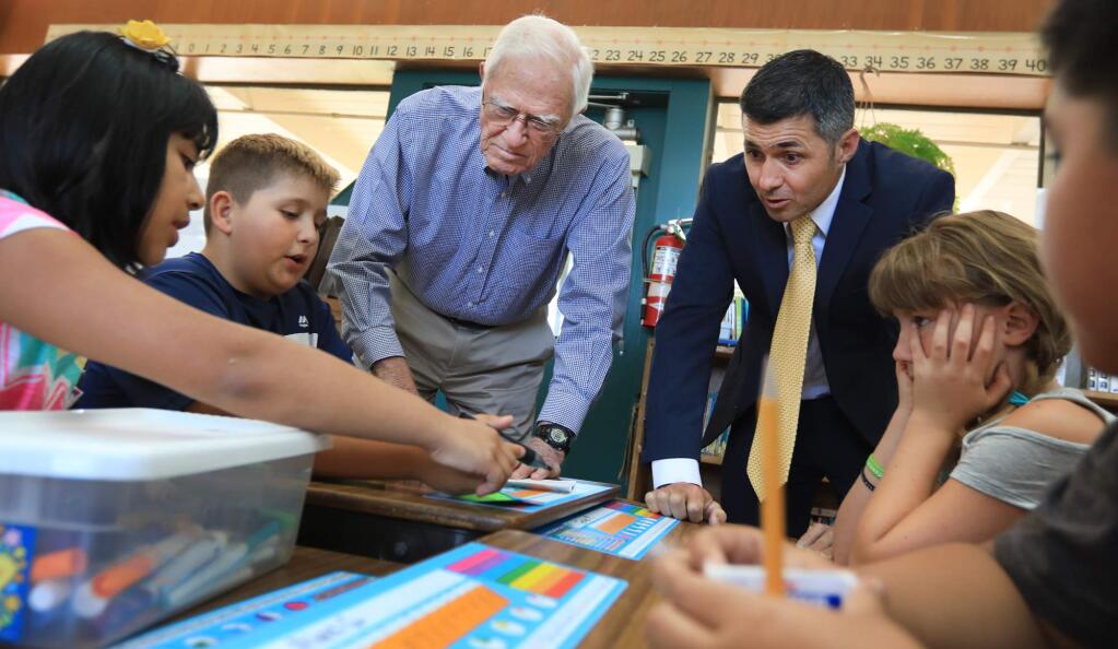 Charles Young, middle left, former chancellor of UCLA, is now the interim superintendent of Sonoma Unified School District. On Wednesday August 23, 2017 Prestwood Elementary School principal Jason Sutter accompanied Young on a tour around the school, which included helping students Valeria Alvarez, Danny Contreras, Grace Missmer and Alex Garcia with classwork. (Kent Porter / The Press Democrat) 2017