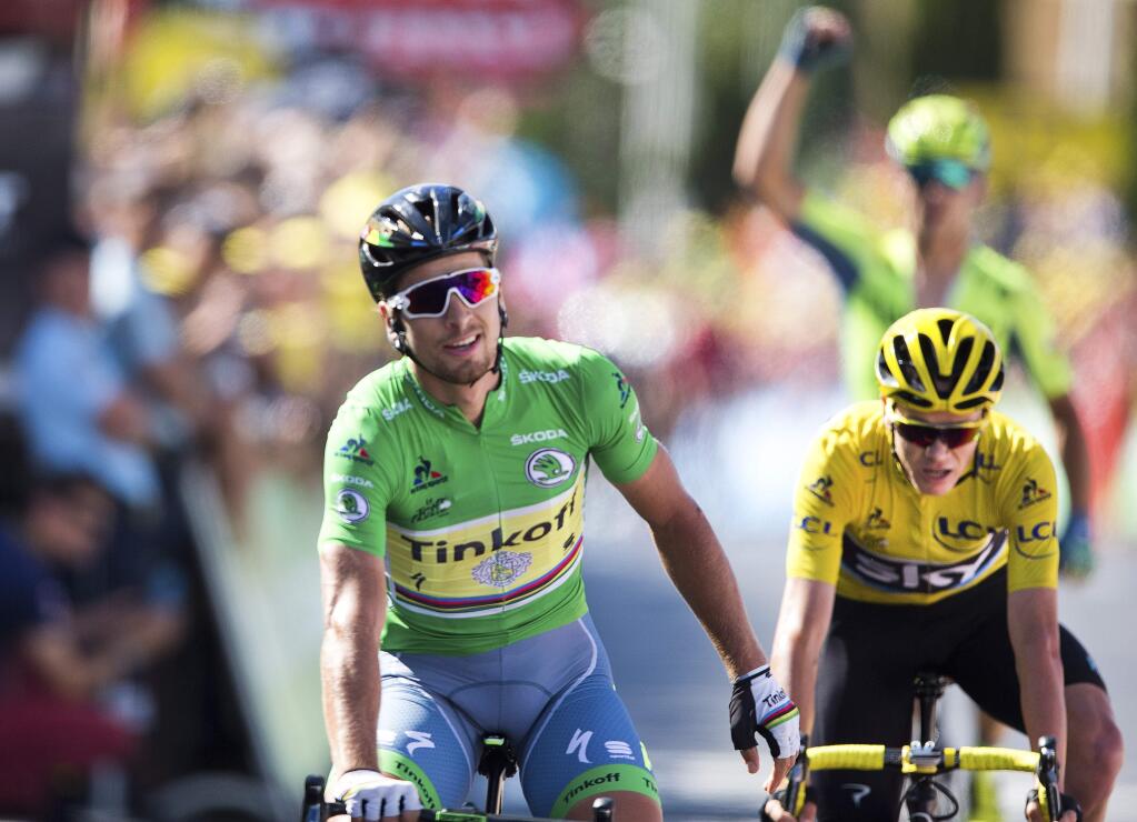 A teammate, rear, of Peter Sagan of Slovakia, front, celebrates as Sagan crosses the finish line ahead of Britain's Chris Froome, wearing the overall leader's yellow jersey, right, to win the eleventh stage of the Tour de France cycling race over 162.5 kilometers (100.7 miles) with start in Carcassonne and finish in Montpellier, France, Wednesday, July 13, 2016. (AP Photo/Peter Dejong)