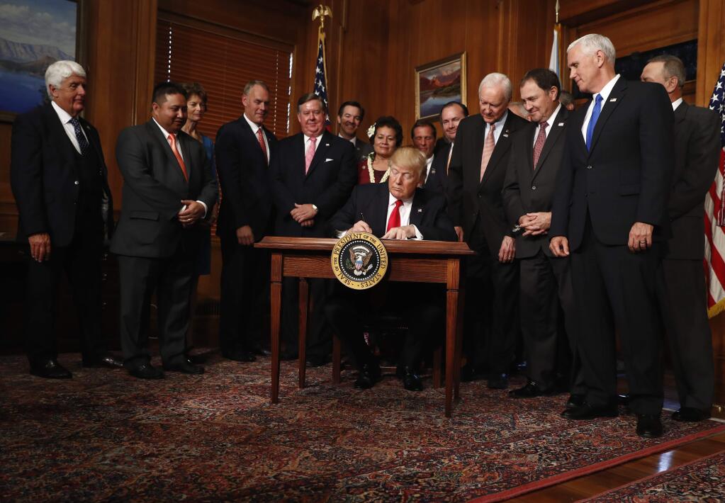 President Donald Trump signs an Antiquities Executive Order during a ceremony at the Interior Department in Washington, Wednesday, April, 26, 2017. President Donald Trump is asking for a review of the designation of tens of millions of acres of land as 'national monuments.' (AP Photo/Carolyn Kaster)