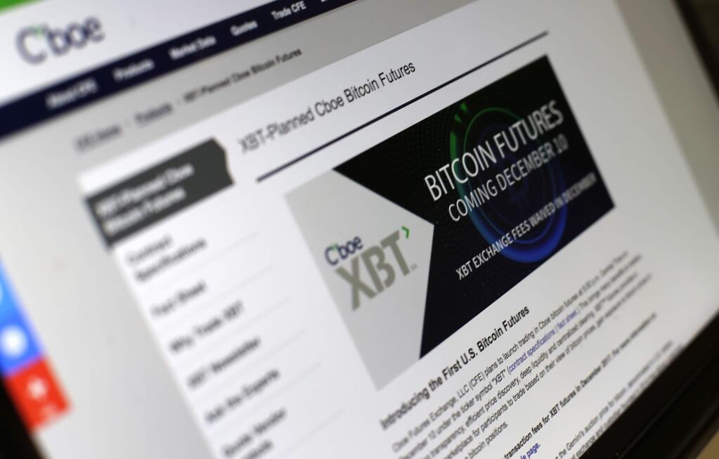 This Friday, Dec. 8, 2017, photo shows the Chicago Board Options Exchange website announcing that bitcoin futures will start trading on the CBOE on Sunday evening, Dec. 10. Bitcoin futures will start trading a week later on the Chicago Mercantile Exchange. (AP Photo/Kiichiro Sato)