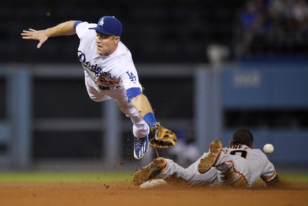 Los Angeles Dodgers second baseman Chase Utley, left, dives for an errant throw from home as San Francisco Giants' Eduardo Nunez steals second during the third inning of a baseball game, Monday, Sept. 19, 2016, in Los Angeles. (AP Photo/Mark J. Terrill)