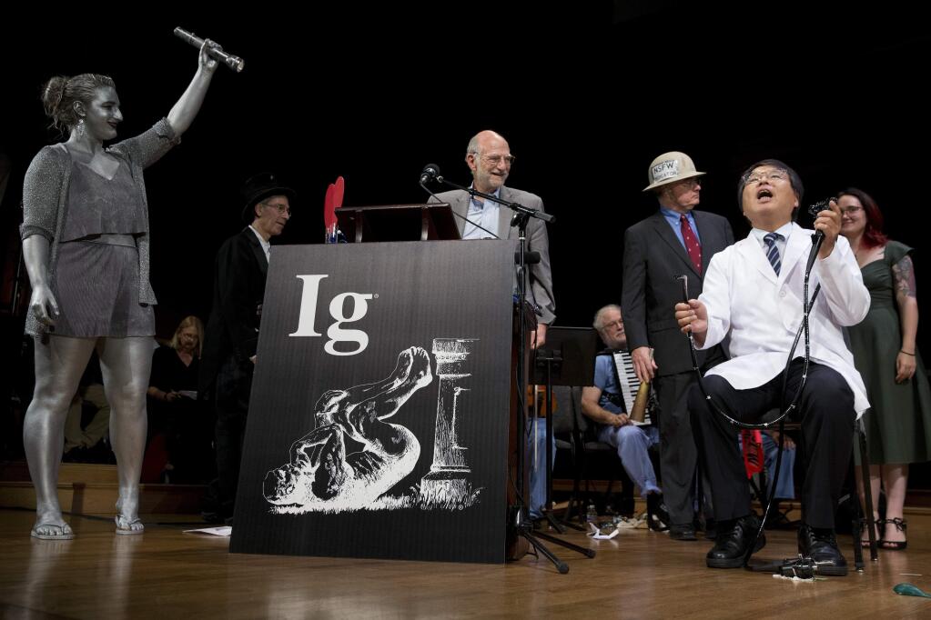 Akira Horiuchi, right, of Japan, who won the Ig Nobel in medical education demonstrates his self colonoscopy technic during award ceremonies at Harvard University in Cambridge, Mass., Thursday, Sept. 13, 2018.(AP Photo/Michael Dwyer)