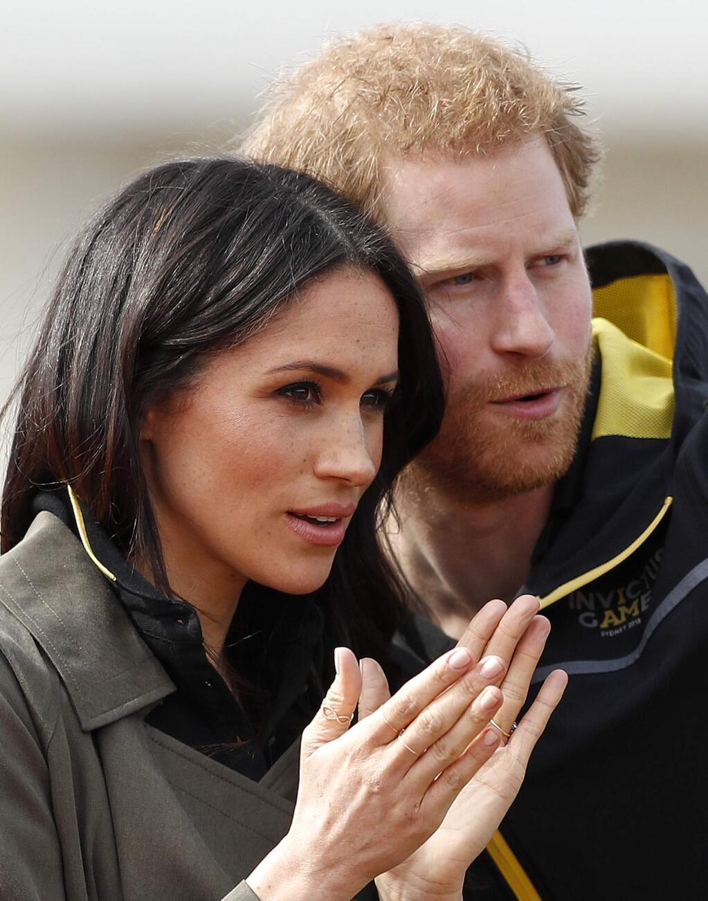 FILE - In this Friday, April 6, 2018 file photo, Britain's Prince Harry and his fiancee Meghan Markle attend the UK team trials for the Invictus Games Sydney 2018 at the University of Bath in Bath, England. Royal wedding organizers on Thursday May 17, 2018, are preparing for a rehearsal of the proceedings to take place in Windsor - but without the bridge and groom. (AP Photo/Frank Augstein, File)