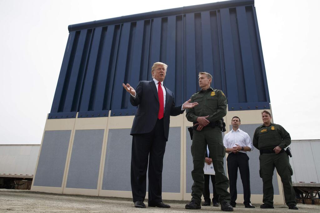 FILE - In this March 13, 2018, file photo, President Donald Trump talks with reporters as he reviews border wall prototypes in San Diego. California's attorney general filed a lawsuit Monday, Feb. 18, 2019, against Trump's emergency declaration to fund a wall on the U.S.-Mexico border. Xavier Becerra released a statement Monday saying 16 states - including California - allege the Trump administration's action violates the Constitution. (AP Photo/Evan Vucci, File)