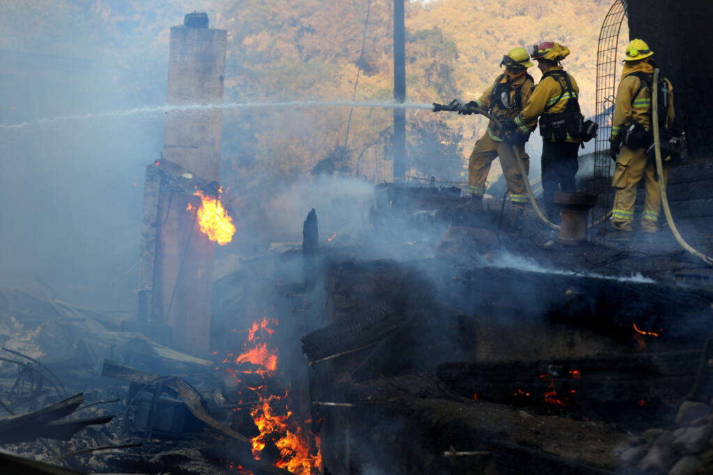 Monterey firefighters work to put out a fire at 11640 Highway 128 east of Chalk Hill Road  during the Kincade Fire near Calistoga, Tuesday, Oct. 29, 2019. (Beth Schlanker / The Press Democrat gile)