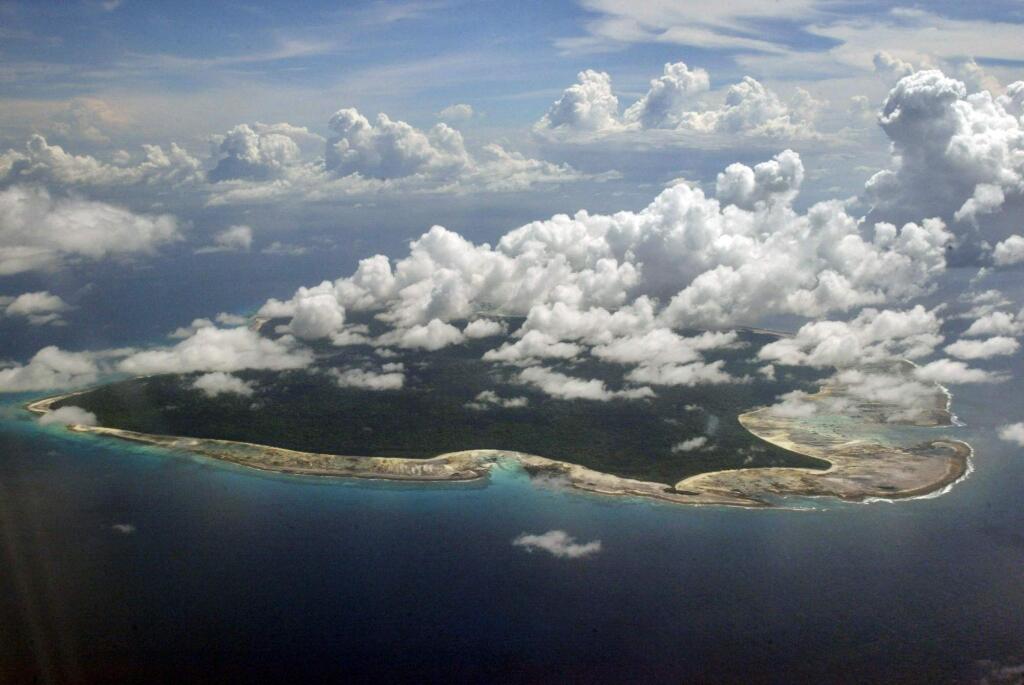 FILE – In this Nov. 14, 2005 file photo, clouds hang over the North Sentinel Island, in India's southeastern Andaman and Nicobar Islands. An American is believed to have been killed by an isolated Indian island tribe known to fire at outsiders with bows and arrows, Indian police said Wednesday, Nov. 21, 2018.Police officer Vijay Singh said seven fishermen have been arrested for facilitating the American's visit to North Sentinel Island, where the killing apparently occurred. Visits to the island are heavily restricted by the government. (AP Photo/Gautam Singh, File)