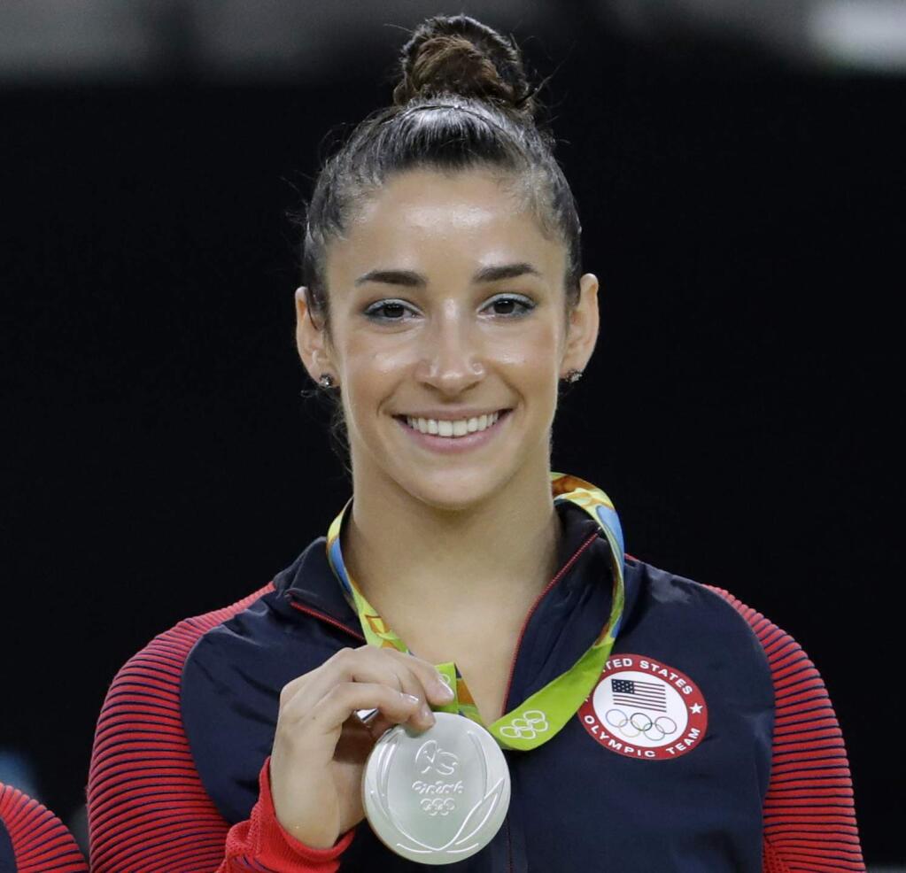 FILE - In this Aug. 16, 2016, file photo, United States' Aly Raisman shows off her silver medal after the artistic gymnastics women's apparatus final at the 2016 Summer Olympics in Rio de Janeiro, Brazil. Six-time Olympic medal winning gymnast Aly Raisman says she is among the young women abused by a former USA Gymnastics team doctor. Raisman tells “60 Minutes” she was 15 when she was first treated by Dr. Larry Nassar, who spent more than two decades working with athletes at USA Gymnastics but now is in jail in Michigan awaiting sentencing after pleading guilty to possession of child pornography. (AP Photo/Dmitri Lovetsky, FIle)