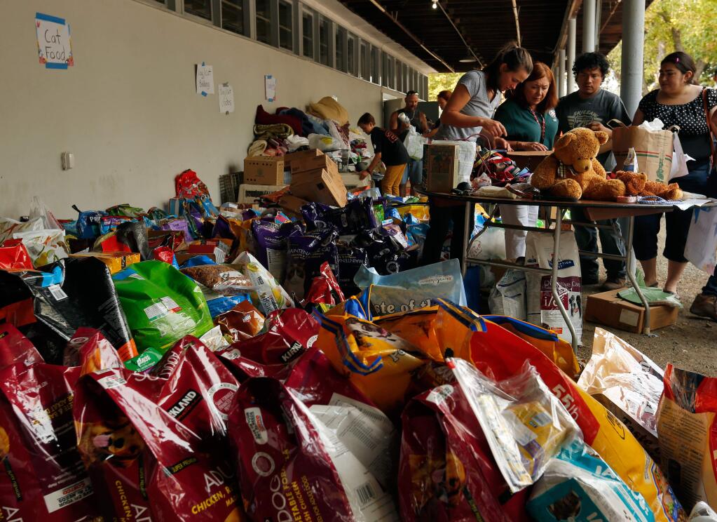 Evacuees look through toys, clothes, pet food, and other household items donated by the local community at the Valley fire evacuation center at Napa County Fairgrounds in Calistoga, California on Sunday, September 13, 2015. Many residents of Cobb Mountain and the Middletown area did not have time to retrieve personal belongings before being evacuated due to the Valley Fire. (Alvin Jornada / The Press Democrat)