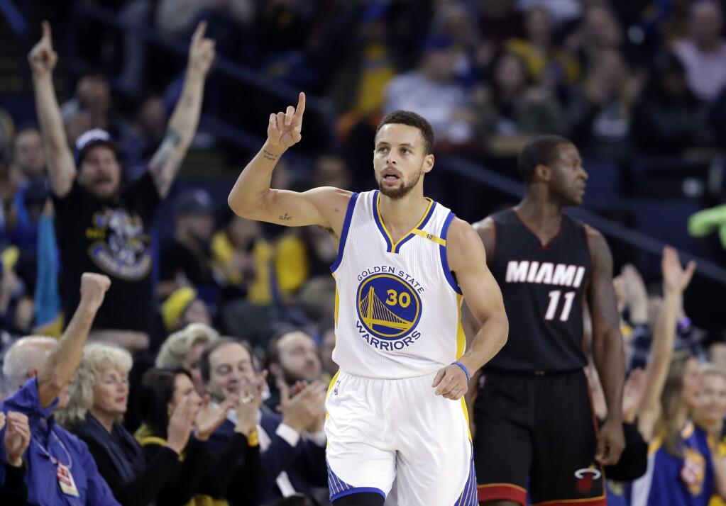 Golden State Warriors' Stephen Curry (30) points after scoring against the Miami Heat during the first half of an NBA basketball game Tuesday, Jan. 10, 2017, in Oakland, Calif. (AP Photo/Marcio Jose Sanchez)
