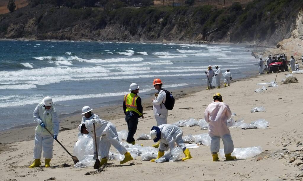 Cleanup crews rake and shovel oil-contaminated sand into bags at El Capitan State Beach, north of Goleta, Calif., Friday, May 22, 2015. Officials say the sheen of oil is now thinner than a coat of paint and is becoming harder to skim from choppy, wind-driven waters. A state parks official says Refugio and El Capitan state beaches and campgrounds will be closed until June 4. That's a week longer than originally announced. The spill from the May 19 break now covers nearly 10 square miles.(AP Photo/Michael A. Mariant)
