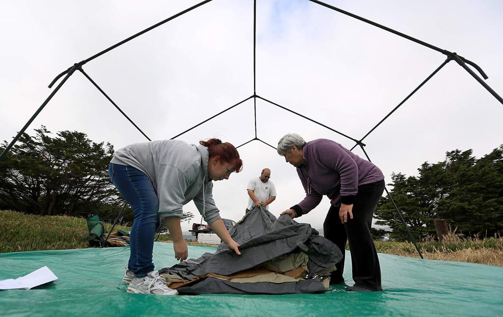 After mastering the frame, Bernadine Learn of Clearlake, left, and Diane Lopez of San Jose help Bill Lowry of Santa Rosa set-up their family tent, Thursday May 21, 2015 at Doran Park Campground in Bodega Bay. (Kent Porter / Press Democrat) 2015
