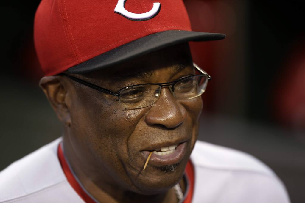 FILE - In this Sept. 20, 2013, file photo, Cincinnati Reds manager Dusty Baker sits in the dugout before a baseball game against the Pittsburgh Pirates in Pittsburgh. Dusty Baker was a big dipper. He's cut back his chaw over the years, but still might pop in a pinch when games get tight. The Washington Nationals manager won't get that choice at some ballparks this season. Big leaguers are now getting a reminder that smokeless tobacco is banned at stadiums in San Francisco, Los Angeles and Boston. (AP Photo/Gene J. Puskar, File)