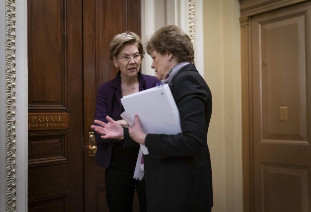 Democratic presidential candidate Sen. Elizabeth Warren, D-Mass., confers with Sen. Jeanne Shaheen, D-N.H., during a series of votes on the war powers resolution which asserts that President Donald Trump must seek approval from Congress before engaging in further military action against Iran, on Capitol Hill in Washington, Thursday, Feb. 13, 2020. (AP Photo/J. Scott Applewhite)