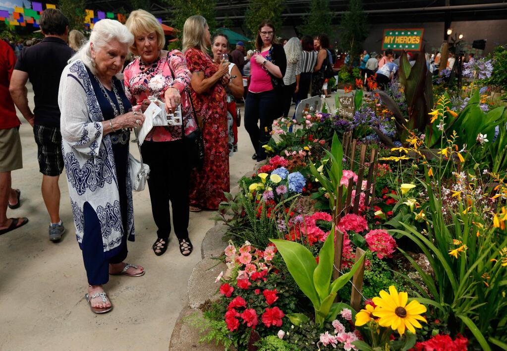 Gwen Adkins, left, and Wendy James, both of Santa Rosa, peruse the flowers in the Coastal Charisma display by botanical artist Daniel R. Gibbs, during the Hall of Flowers preview at the 82nd annual Sonoma County Fair in Santa Rosa, California, on Wednesday, Aug. 1, 2018. (ALVIN JORNADA/ PD)