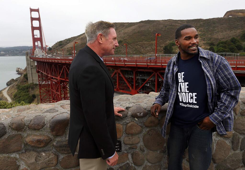 Former CHP officer Kevin Briggs of Petaluma, left, with Kevin Berthia, one of the more than 200 people he talked out of suicide while working on the Golden Gate Bridge. Briggs has written a book about his experiences, 'Guardian of the Golden Gate.' (JOHN BURGESS / The Press Democrat)