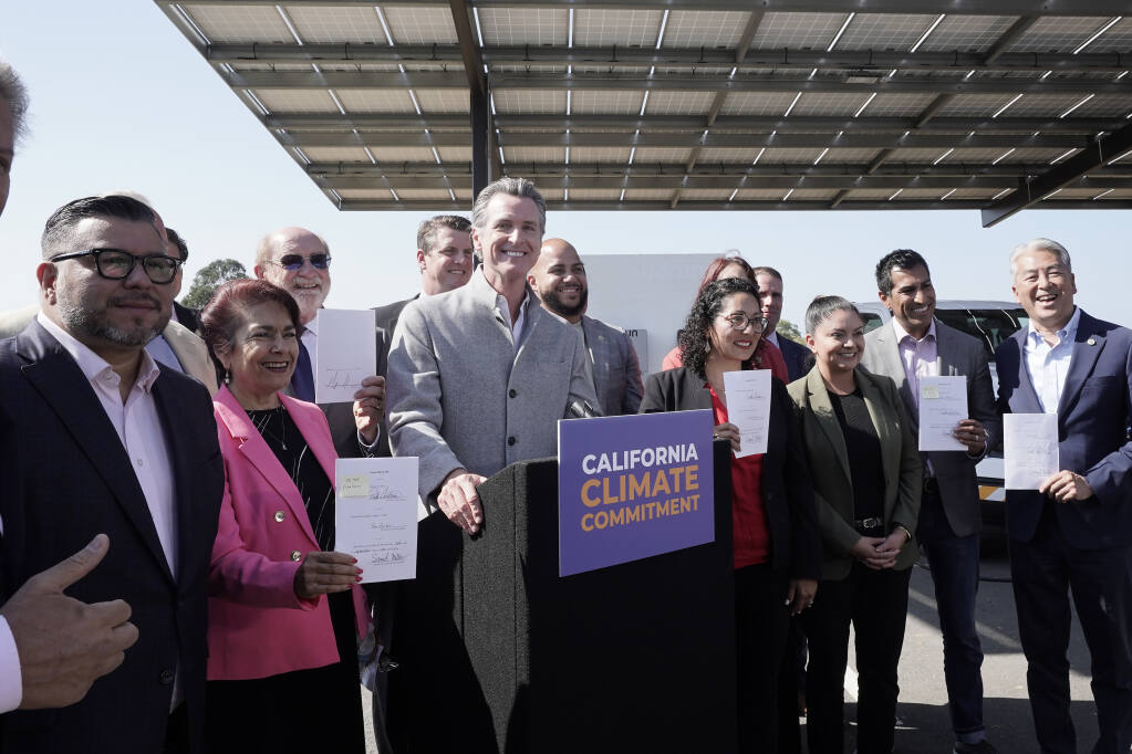 Gov. Gavin Newsom, center, poses with lawmakers after signing a package of legislation that accelerates the climate goals of the nation's most populous state at Mare Island in Vallejo, Calif., Friday, Sept. 16, 2022. (AP Photo/Rich Pedroncelli)