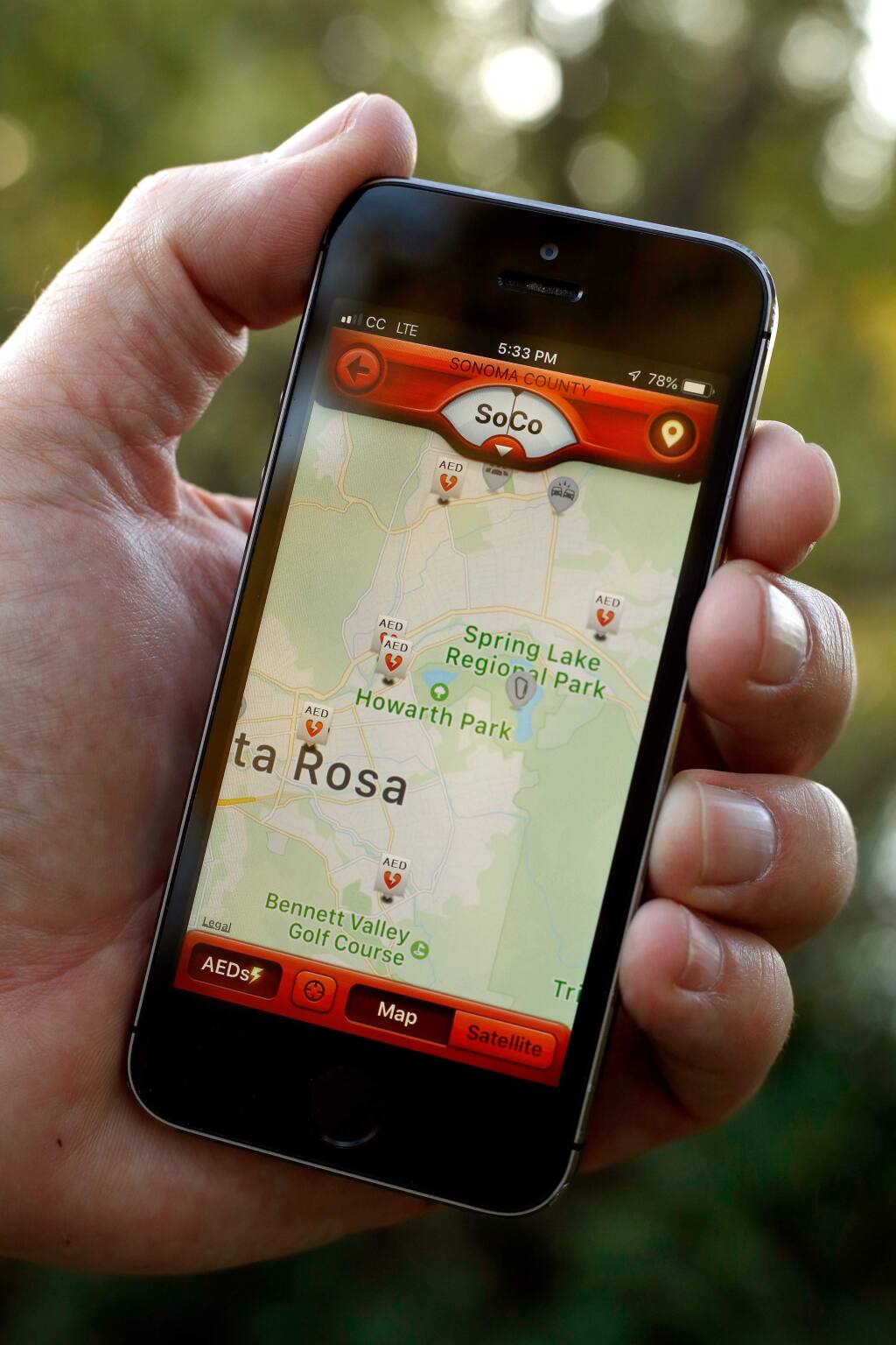 Dave Smith of Save Lives Sonoma holds his smartphone with the PulsePoint Respond app showing a map of automated external defibrillators locations around Spring Lake Park in Santa Rosa, California, on Friday, October 19, 2018. (Alvin Jornada / The Press Democrat)