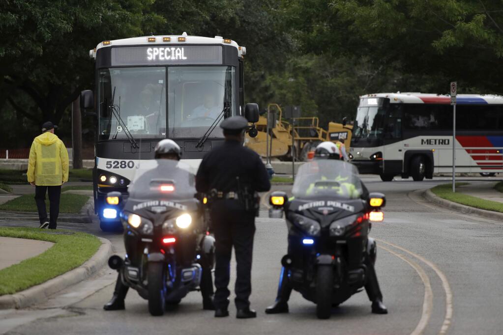 Buses carrying attendees arrive at St. Martin's Episcopal Church for a funeral service for former first lady Barbara Bush, Saturday, April 21, 2018, in Houston. (AP Photo/Evan Vucci)