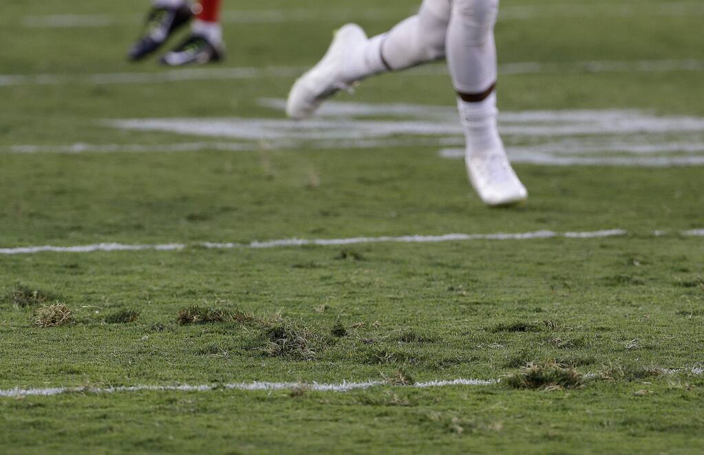 A San Francisco 49ers player runs on the field at Levi's Stadium during the team's NFL football training camp in Santa Clara, Calif., Saturday, Aug. 1, 2015. It took less than a half-hour into the 49ers first practice for the Levis Stadium sod to come up in pieces, also only a couple of hours after the venue hosted a high school all-star game. (AP Photo/Jeff Chiu)