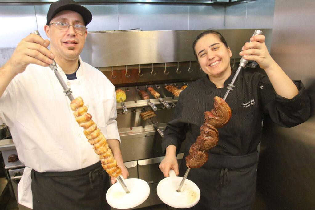 Chef/Owner Cristina Fara holds BBQed top sirloin while Sous Chef Justin Masingale holds BBQed bacon wrapped chicken at BraislBBQ in Petaluma on Monday January 11, 2016. (SCOTT MANCHESTER/ARGUS-COURIER STAFF)