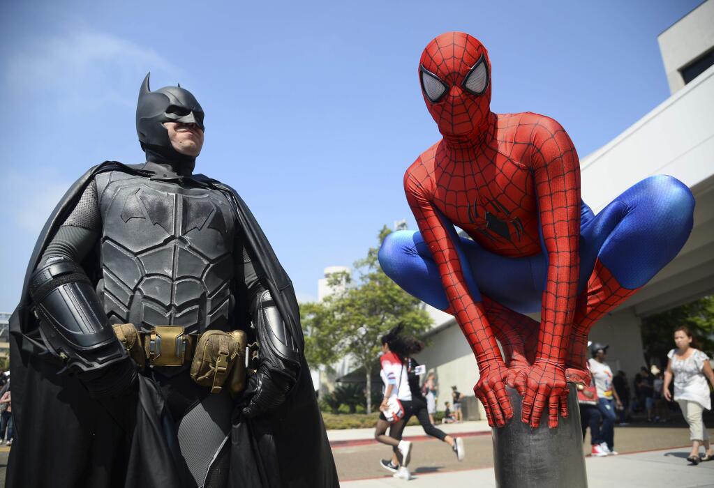 FILE - In this July 23, 2016 file photo, Dorian Black, left, dressed as Batman and Kyle Blankenfield, dressed as Spider-Man appear outside during Comic-Con International in San Diego. The annual pop-culture celebration kicks off Wednesday night with a preview of the San Diego Convention Center's showroom floor. Four days of panels, presentations, screenings and autograph signings begin on Thursday. (Photo by Al Powers/Invision/AP, File)