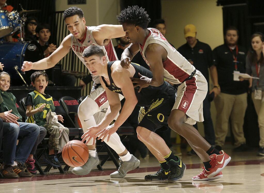 Oregon guard Payton Pritchard, center, dribbles between Stanford guard Dorian Pickens, left, and Marcus Allen during the first half of an NCAA college basketball game in Stanford, Calif., Saturday, Feb. 25, 2017. (AP Photo/Jeff Chiu)