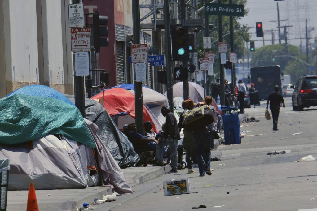 FILE - In this May 30, 2019 file photo tents housing homeless line a street in downtown Los Angeles. The number of homeless people counted across Los Angeles County jumped 12% over the past year to a total of 58,936. The Los Angeles Homeless Services Authority presented the results of January's annual count to the Board of Supervisors on Tuesday, June 4. (AP Photo/Richard Vogel,File)
