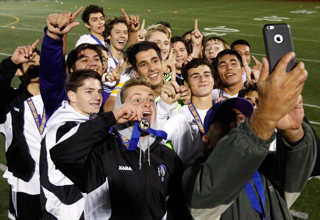 The Petaluma Trojans boys varsity soccer team celebrates their NCS Division 1 championship win over Fortuna with a group photo taken by assistant coach Timo Rivetti on Saturday, Nov. 14, 2015. (Alvin Jornada / The Press Democrat)