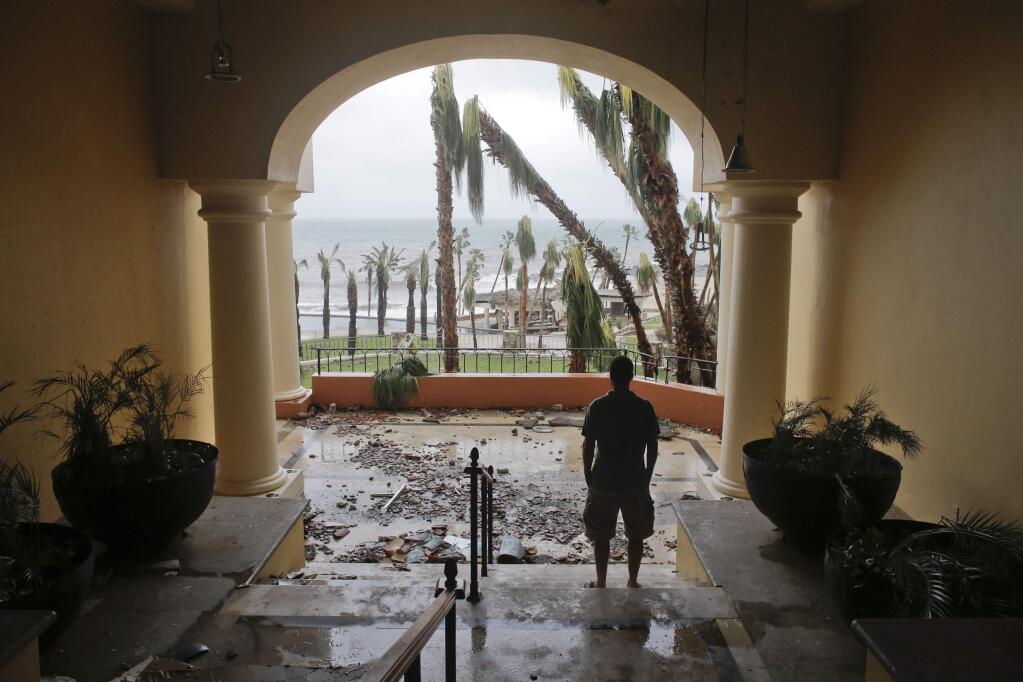 A tourists looks to the ocean from inside a debris-filled area at the Hilton hotel after the resort sustained severe damage from Hurricane Odile in Los Cabos, Mexico, Monday, Sept. 15, 2014. Hurricane Odile blazed a trail of destruction through Mexico's Baja California Peninsula that leveled everything from ramshackle homes to big box stores and luxury hotels, leaving roads and entire neighborhoods as disaster zones. (AP Photo/Victor R. Caivano)