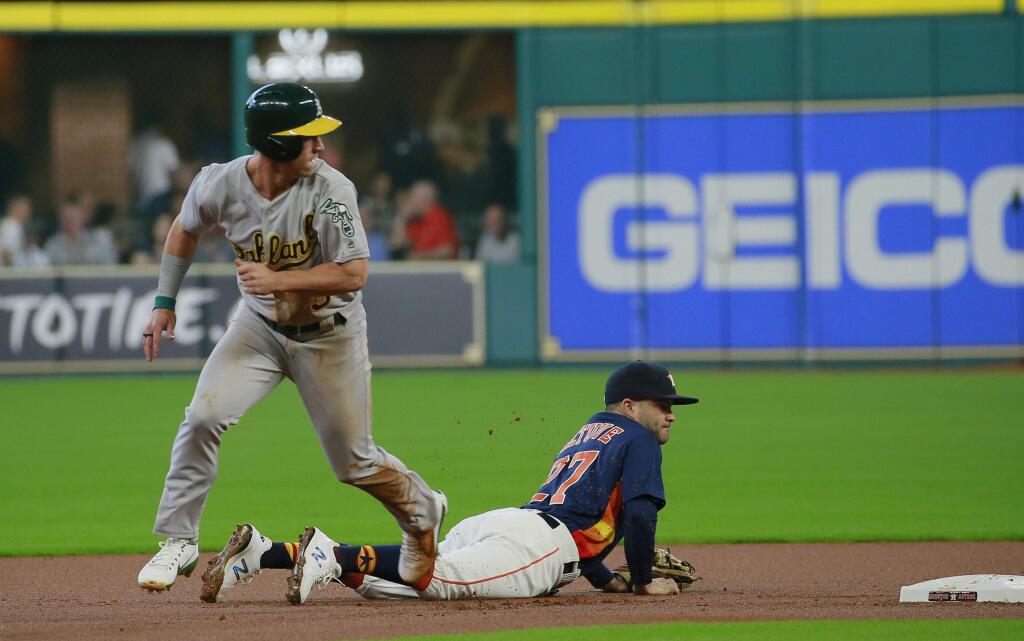 Oakland Athletics' Boog Powell, left, looks as he advances to score on a throwing error to Houston Astros' Jose Altuve in the first inning of a baseball game, Sunday, Aug. 20, 2017, in Houston. (AP Photo/Richard Carson)