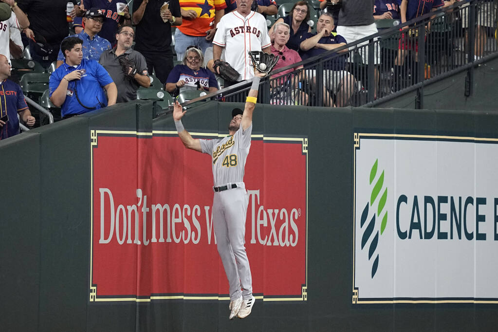 A’s left fielder Cody Thomas catches a fly ball in foul territory by the Astros’ Yordan Alvarez during the fifth inning Thursday, Sept. 15, 2022, in Houston. (David J. Phillip / ASSOCIATED PRESS)
