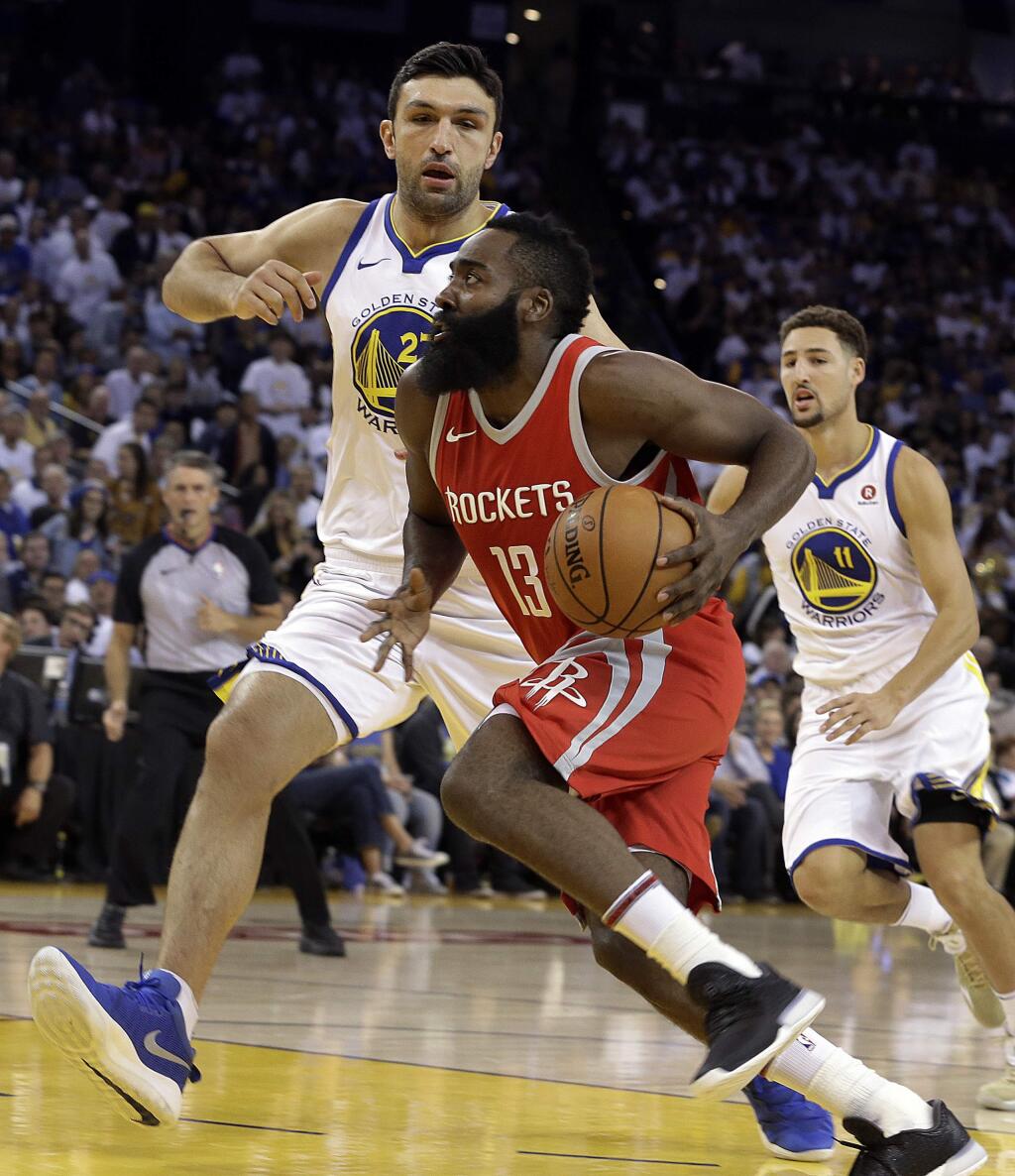 The Houston Rockets' James Harden drives the ball against the Golden State Warriors' Zaza Pachulia, left, during the first quarter Tuesday, Oct. 17, 2017, in Oakland. (AP Photo/Ben Margot)