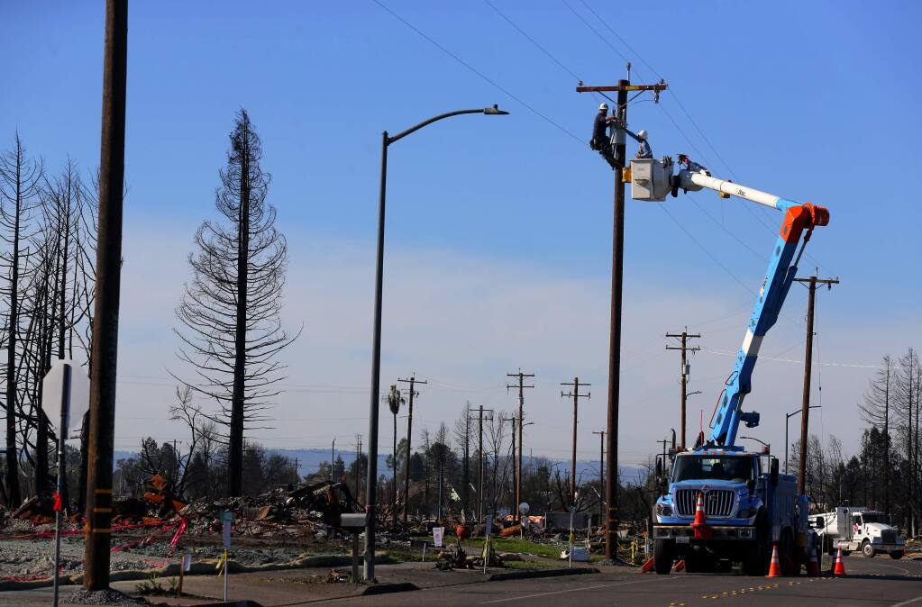 A PG&E crew works on power lines along Hopper Avenue, in the Coffey Park area of Santa Rosa on Thursday, Dec. 7, 2017. (Christopher Chung/ The Press Democrat)